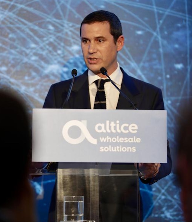 Um homem discursa num pódio em frente a um ecrã sobre o investimento de 3 milhões de euros da Altice Portugal num novo Centro de Interligação de Redes Internacionais.