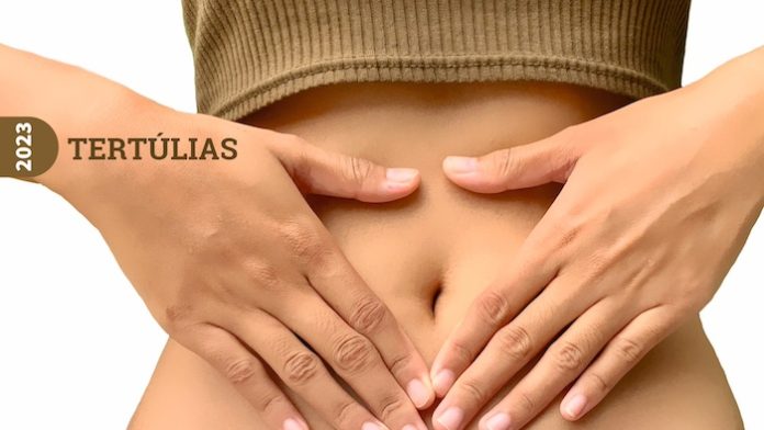 Quarteira-Tertúlia-Saúde-Intestinal Mulher a participar na sessão de Quarteira sobre Saúde Intestinal, com as mãos na barriga.